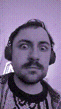 a selfie of a white person, wearing either headphones or a helmet, making an odd expression. the photo is edited to be colorized into a monochrome purple-ish color palette.